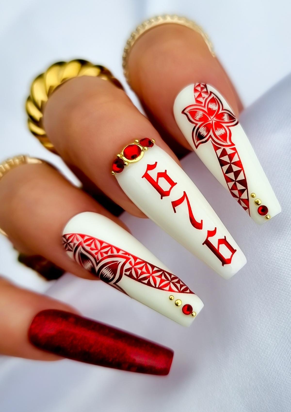 Red and white set of nails with red Tongan patterns , flowers and red and gold accents. Numbers 676 on middle fingernail.
