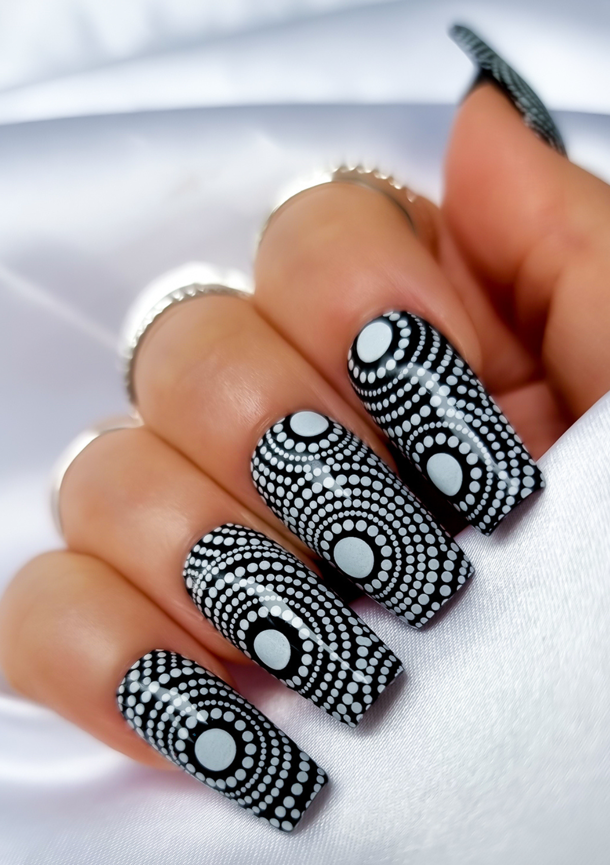 Black nails with white Aboriginal Australian nail art designs
