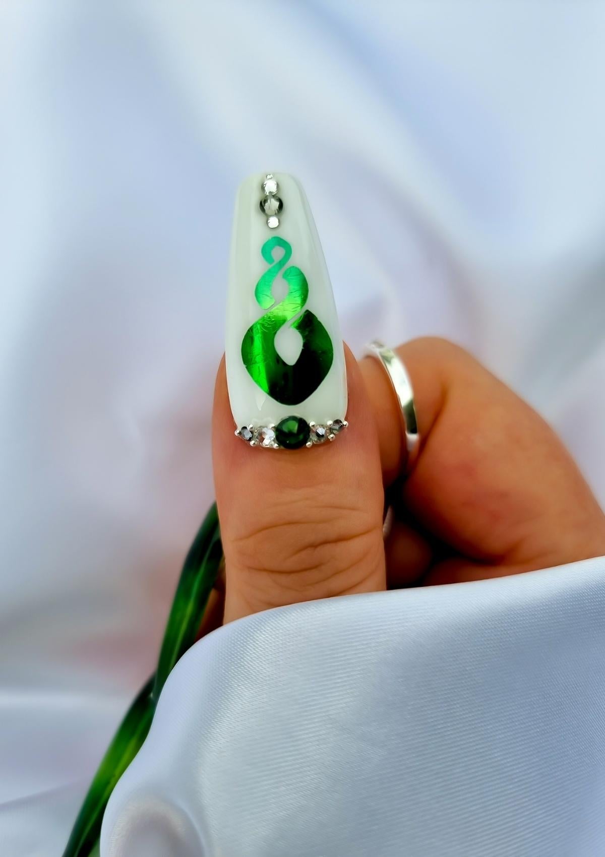 White nail with green pikorua twist Maori Nail Foil and crystals