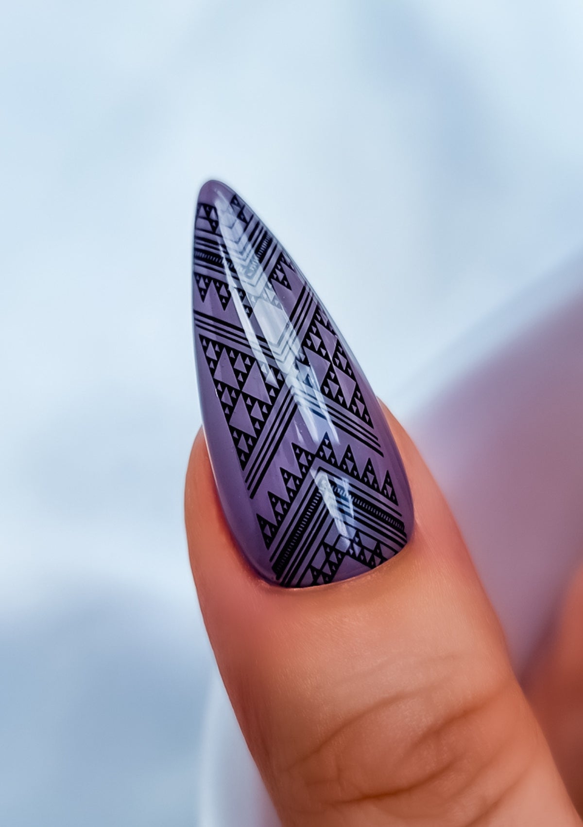 Long almond shaped thumb nail in mauve with black Maori nail art. Nail art design in Taniko Hou pattern by Adrienne Whitewood.  